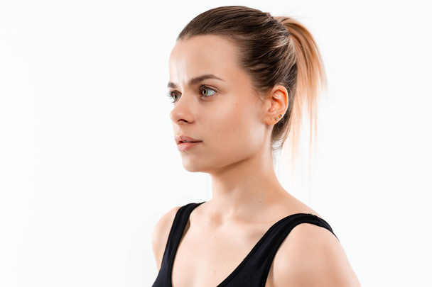 Young sporty blond woman in a black sportswear exercising isolated over white background. - Foto, afbeelding