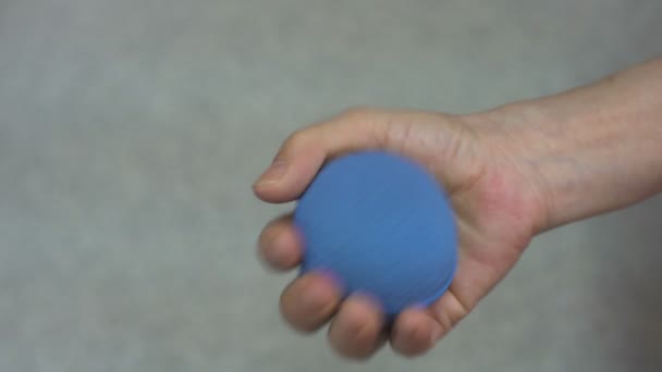 masculino mão realizando terapia ocupacional com bola azul - Filmagem, Vídeo