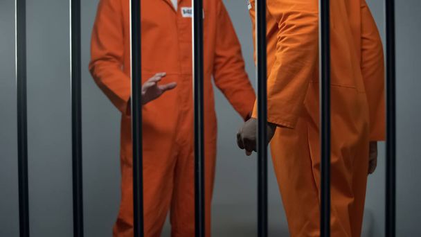 Aggressive black prisoner threatening caucasian inmate jail overcrowding assault - Valokuva, kuva