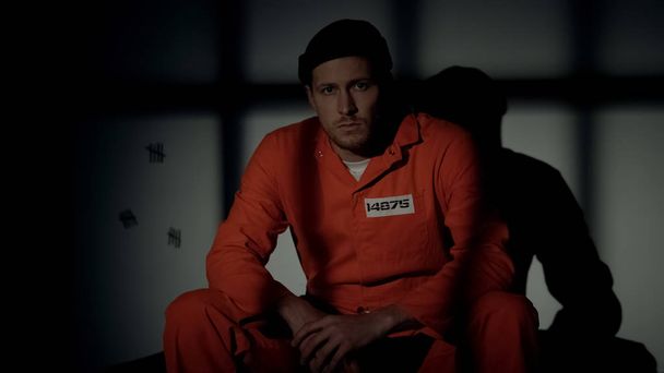 Male prisoner sitting in cell when light starting to burn, escape and riot risk - Valokuva, kuva