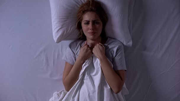 Attractive woman crying lying in bed at night, female weakness and fragility - Foto, Bild