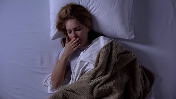 Blonde woman waking-up at night and feeling nausea, sickness, intestinal flu - Photo, image