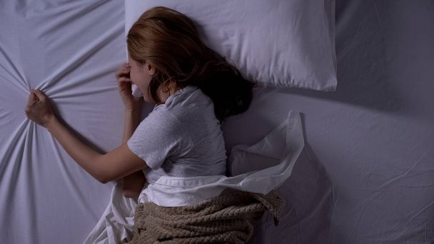 Lonely lady crying in bed night, spouse loss, sad memories, suffering depression - Фото, изображение