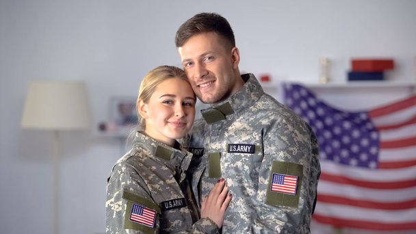 Cheerful couple of US soldiers hugging and looking at camera, found love on duty - Foto, Imagem