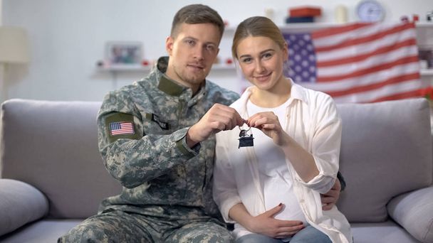 American male soldier and his wife holding house key reward for military service - Foto, Imagen