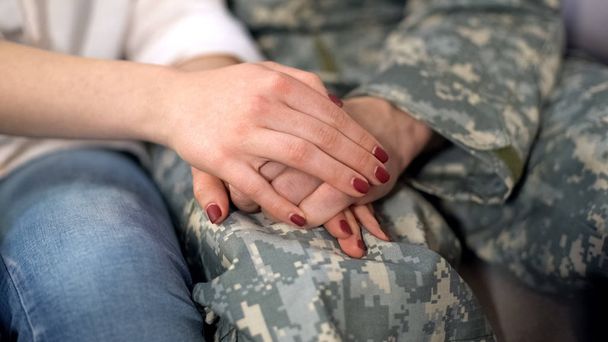 Military man and girlfriend holding hands, supporting boyfriend before leaving - Valokuva, kuva