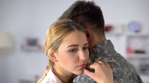 Sad girlfriend hugging male soldier, farewell before military service depression - 写真・画像