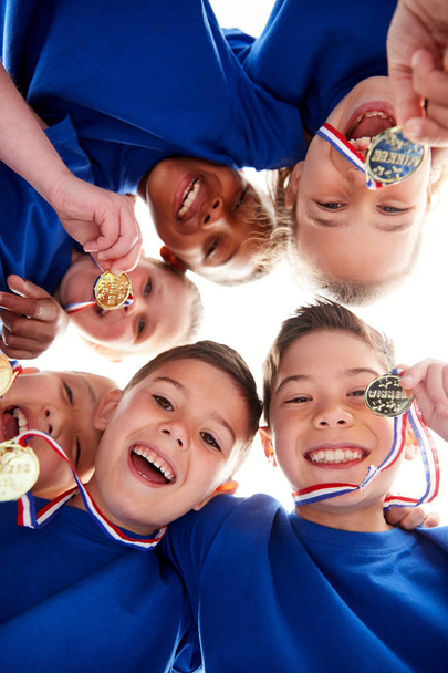 Low Angle View Looking Up Into Faces Of Children In Huddle On Sports Day - Фото, зображення