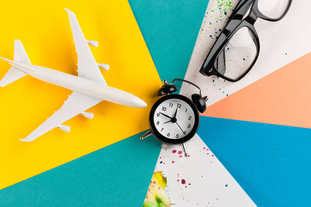 Time to travel concept. plastic plane jet toy passenger with alarm clock  - Φωτογραφία, εικόνα