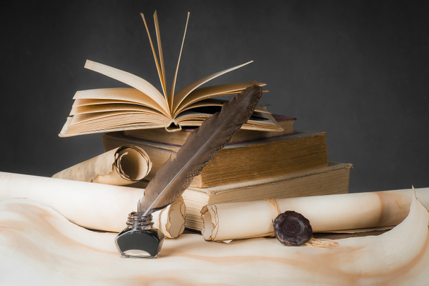 Папірус прокручується на стільниці з книгами, ручкою і капотом
 - Фото, зображення