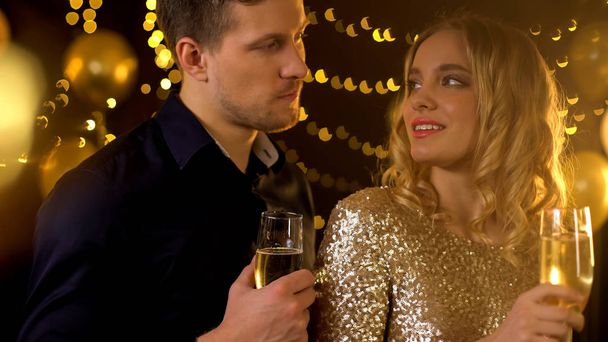 Flirtare coppia tenendo bicchieri da vino e guardando l'un l'altro, atmosfera festiva
 - Foto, immagini