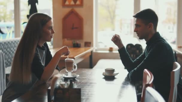 Dívka a muž mluví v kavárně ve městě - Záběry, video