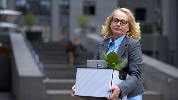 Sad dismissed business woman holding stuff box, unprofessional worker, failure - Фото, изображение