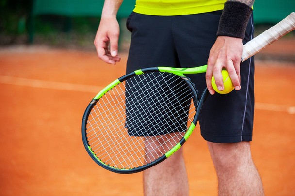 Closeup male tennis player holding racket and ball. - 写真・画像