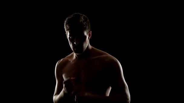 Topless free fighter preparing for sparing, dark background, shadow fight - Valokuva, kuva