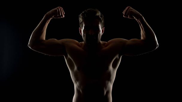 Uomo furioso che mostra muscoli bicipiti, dimostrando potenza, pronto per la lotta illegale
 - Foto, immagini