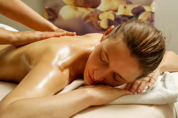 Yağ sırt masajı, esansiyel yağ ile aromaterapi masajı olan spa bir kadın - Fotoğraf, Görsel