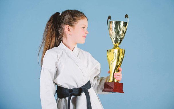 Girl little child in white kimono with belt. Karate fighter child. Karate sport concept. Self defence skills. Karate gives feeling of confidence. Celebrate achievement. Strong and confident kid - Foto, immagini