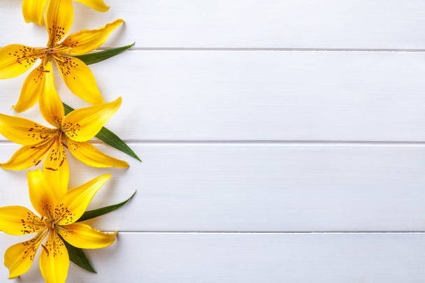 Grandes fleurs jaunes lis sur vieux fond blanc minable avec espace de copie. Carte de vœux floral, pose plate
. - Photo, image