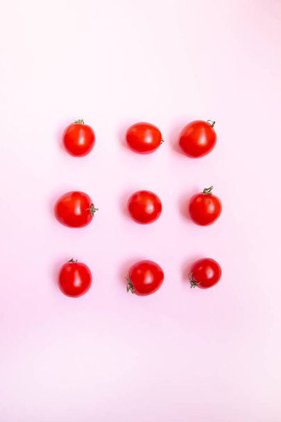 Dieta saludable vitaminas bio productos. Tomates rojos maduros dulces sobre un fondo rosa, vista superior con lugar para el texto
. - Foto, imagen