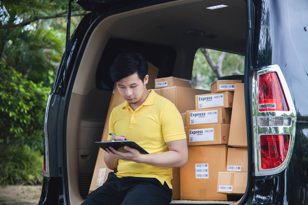 Młody Asian Delivery Man sprawdzenie listy opakowań - Zdjęcie, obraz