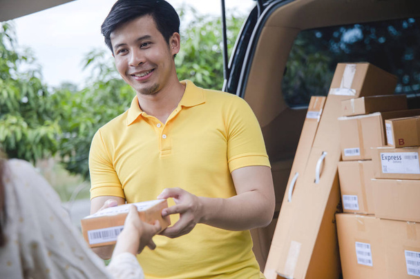 Joven asiático entrega hombre paquetes al cliente
 - Foto, Imagen