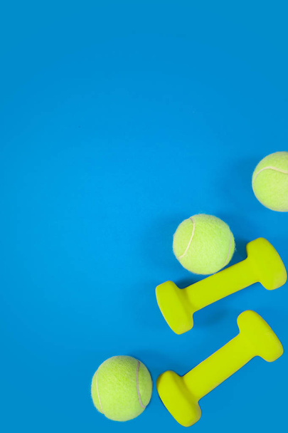 workout concept fitness background dumbells tennis ball on blue background - 写真・画像