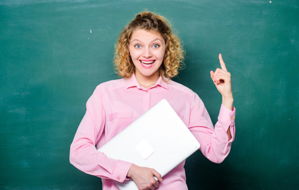 Software for teachers. Modern education. Teaching informatics. Back to school. School lecturer with notebook. Woman cheerful teacher hold laptop stand near chalkboard. School education concept - 写真・画像