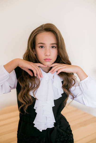 Cute girl with long  curly hair in school fashion clothes. School fashion in vintage elite style. - Foto, Imagem