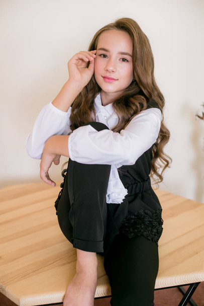 Cute girl with long  curly hair in school fashion clothes. School fashion in vintage elite style. - Фото, изображение
