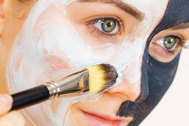 Girl black mask on half face apply white mud - Fotografie, Obrázek