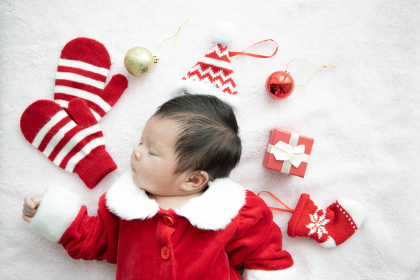 Asian baby newborn on Santa claus uniform sleeping with red box  - Foto, Imagem