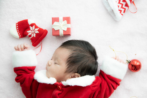 Asian baby newborn on Santa claus uniform sleeping with red box  - Photo, Image