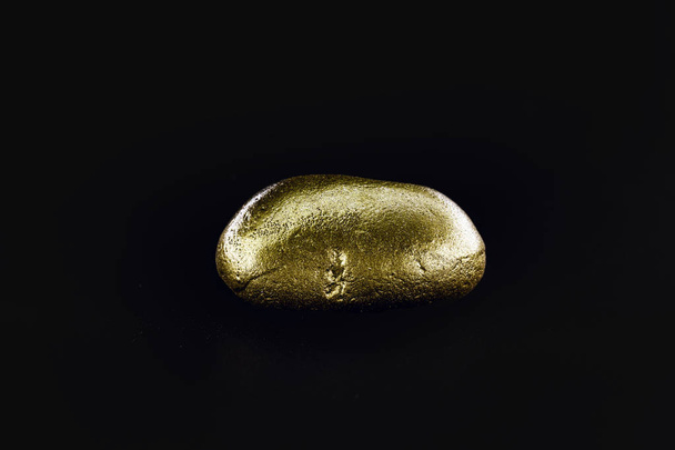 Gold nugget, large gold stone closeup isolated on black background. Concept of finance, luxury or wealth. - Photo, Image