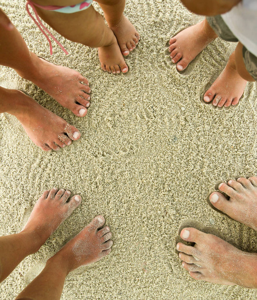 Pés de família na areia na praia
 - Foto, Imagem