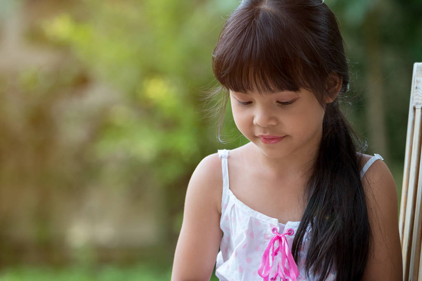 Aranyos ázsiai lány lennél ülve nyilvános parkban - Fotó, kép
