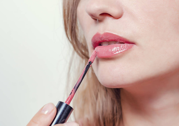 Female lips are painted with red lipstick, closeup. - Φωτογραφία, εικόνα
