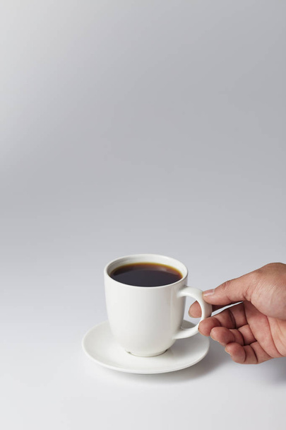 Рука тримає білу чашку кави
 - Фото, зображення
