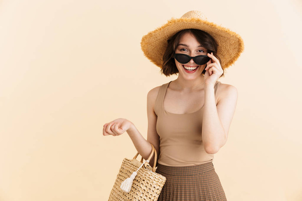 Portrait of joyous brunette woman wearing straw hat and sunglass - Foto, Imagen