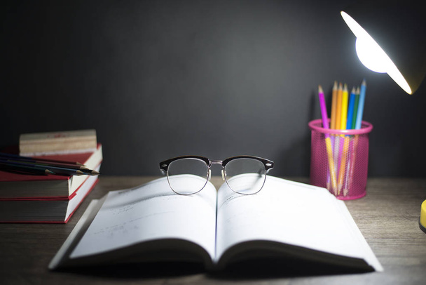 Читання столу вночі, окуляри розміщені на відкритій книзі, і світло
 - Фото, зображення