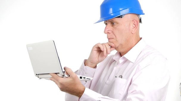 Serious Engineer Read Financial News on Laptop Screen - 写真・画像