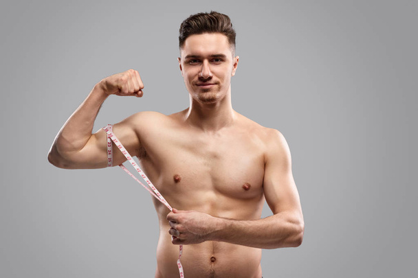 Confident athlete measuring biceps - Foto, Imagem
