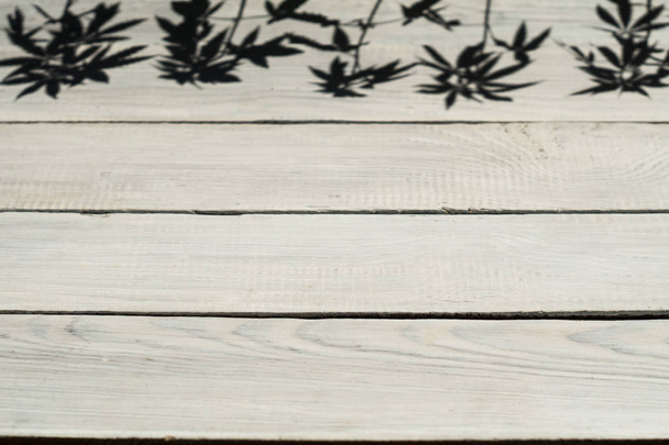 La sombra de las plantas de cáñamo sobre la superficie de madera
 - Foto, Imagen