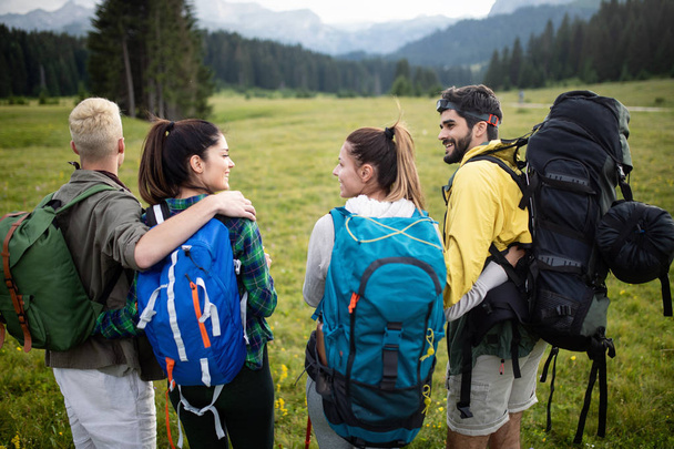 Un gruppo di amici sta facendo escursioni in montagna in una giornata di sole
 - Foto, immagini