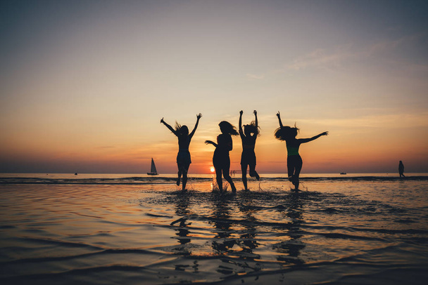 Beautiful party girls silhouette on sea. Happy people. - Foto, afbeelding