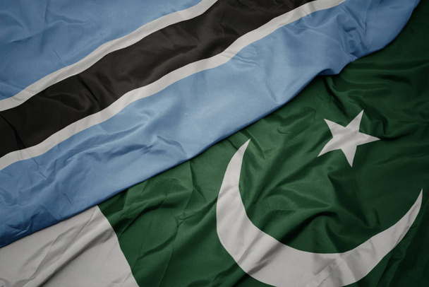 махаючи барвистим прапором Пакистану і національним прапором ботсвани
. - Фото, зображення