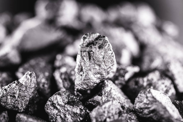 黒の背景に大きな銀のナゲット。生の銀の石、リベリアからのネイティブシルバーナゲット、黒の背景に隔離。ミネラル抽出. - 写真・画像