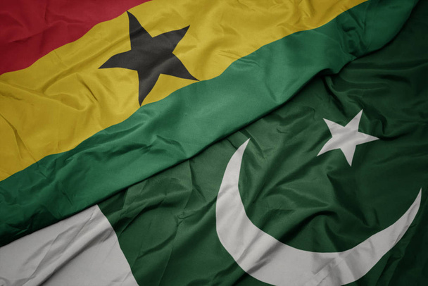 махаючи барвистим прапором Пакистану і національним прапором Гани
. - Фото, зображення
