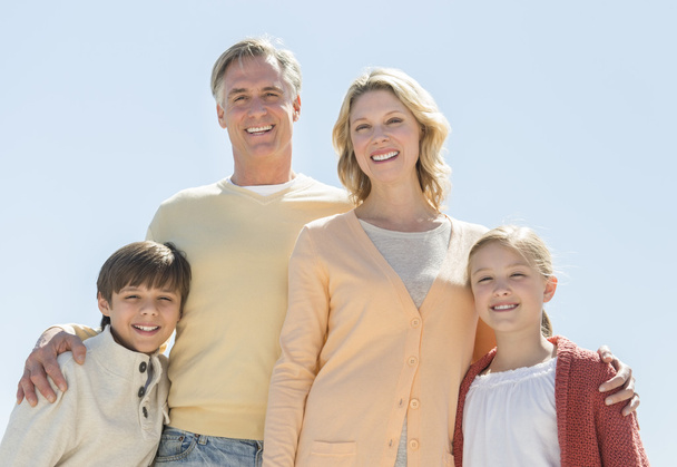 glückliche vierköpfige Familie vor strahlend blauem Himmel - Foto, Bild