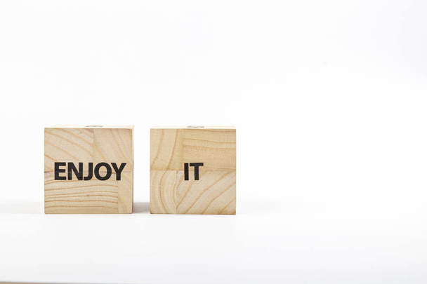 Wooden cubes with the inscription enjoy it on a white background - Photo, Image